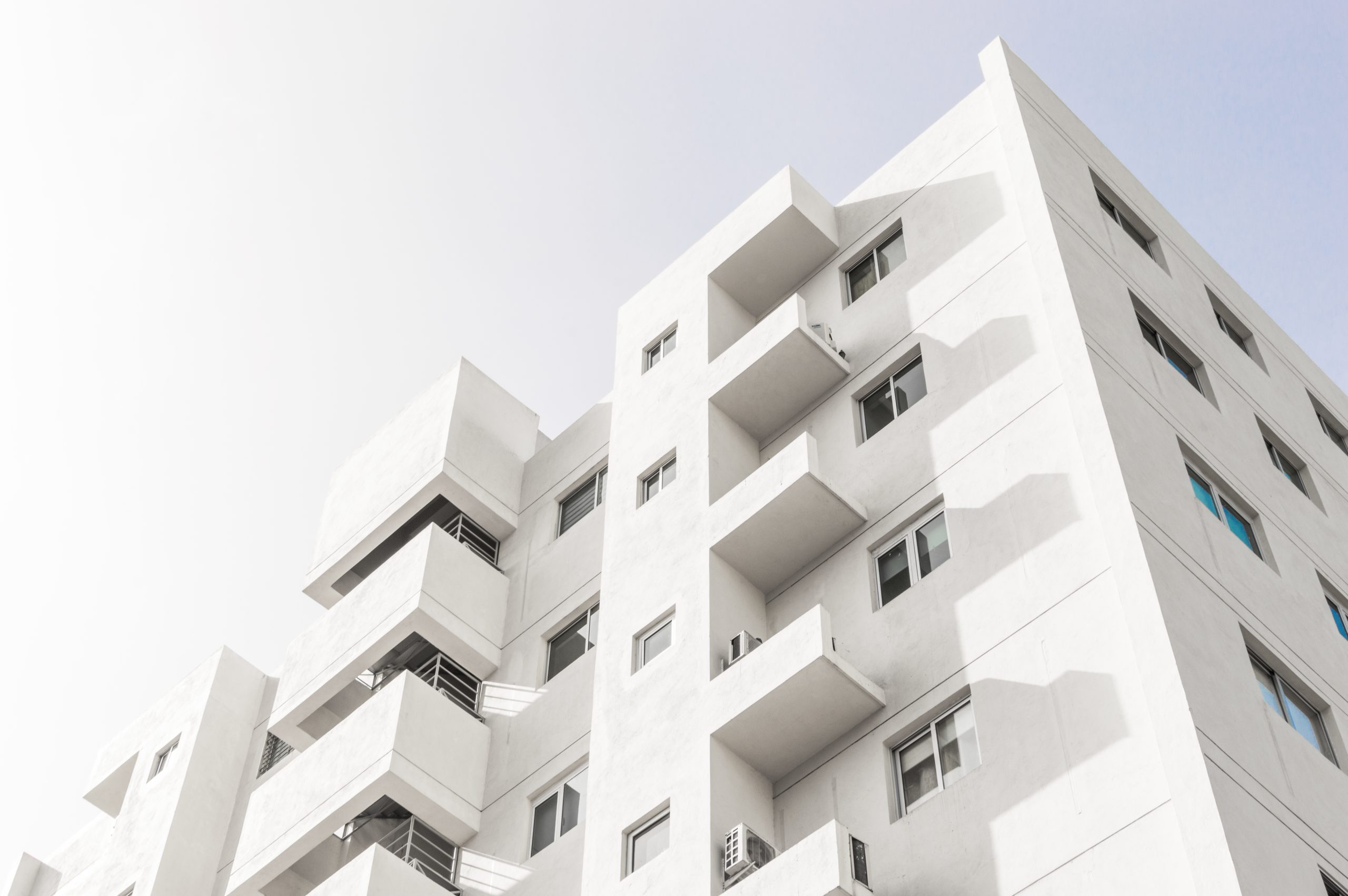 comprar apartamento: fachada de um prédio residencial branco