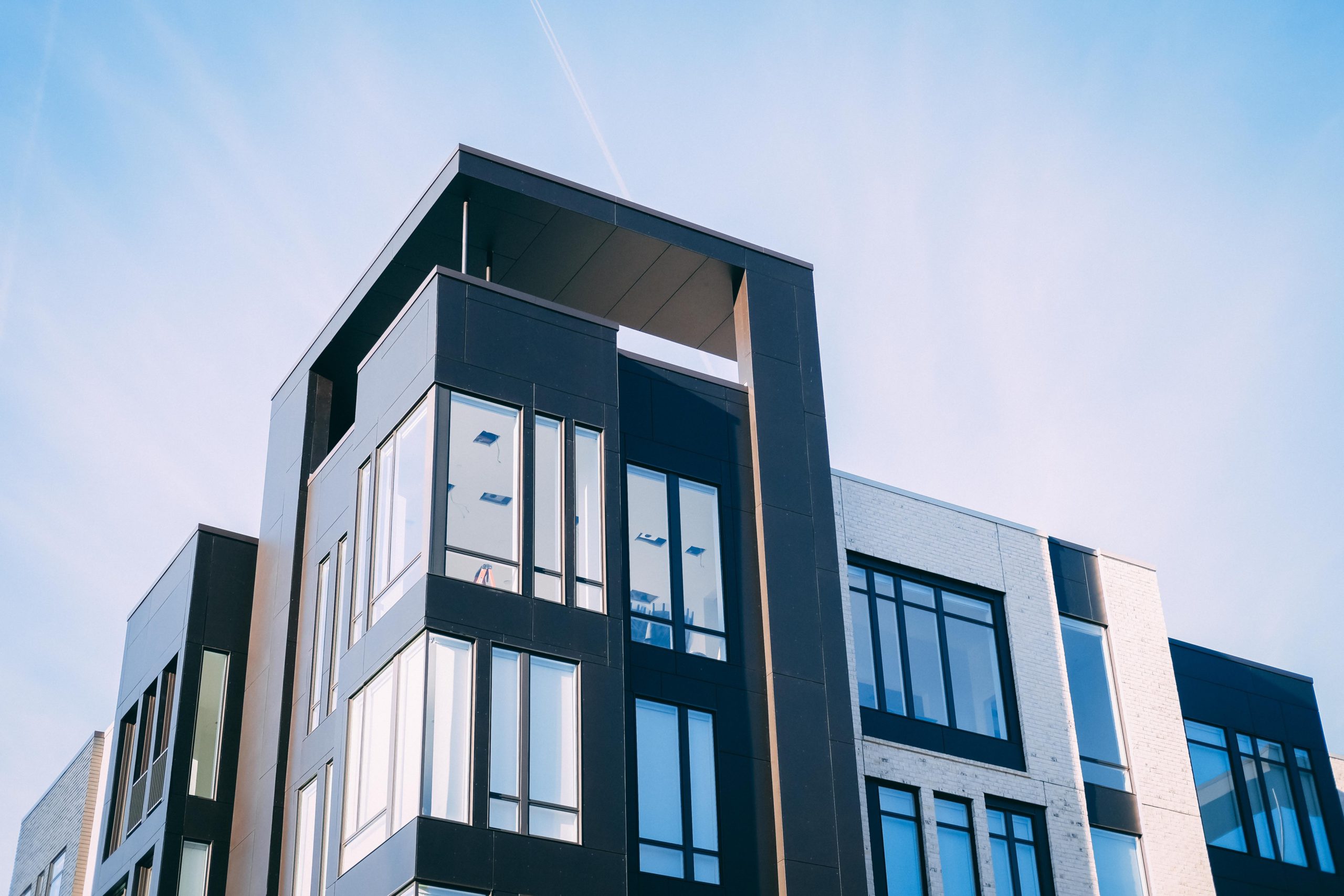 Compra apartamento pequeno: imagem da fachada de um prédio de apartamentos com janelas de vidro