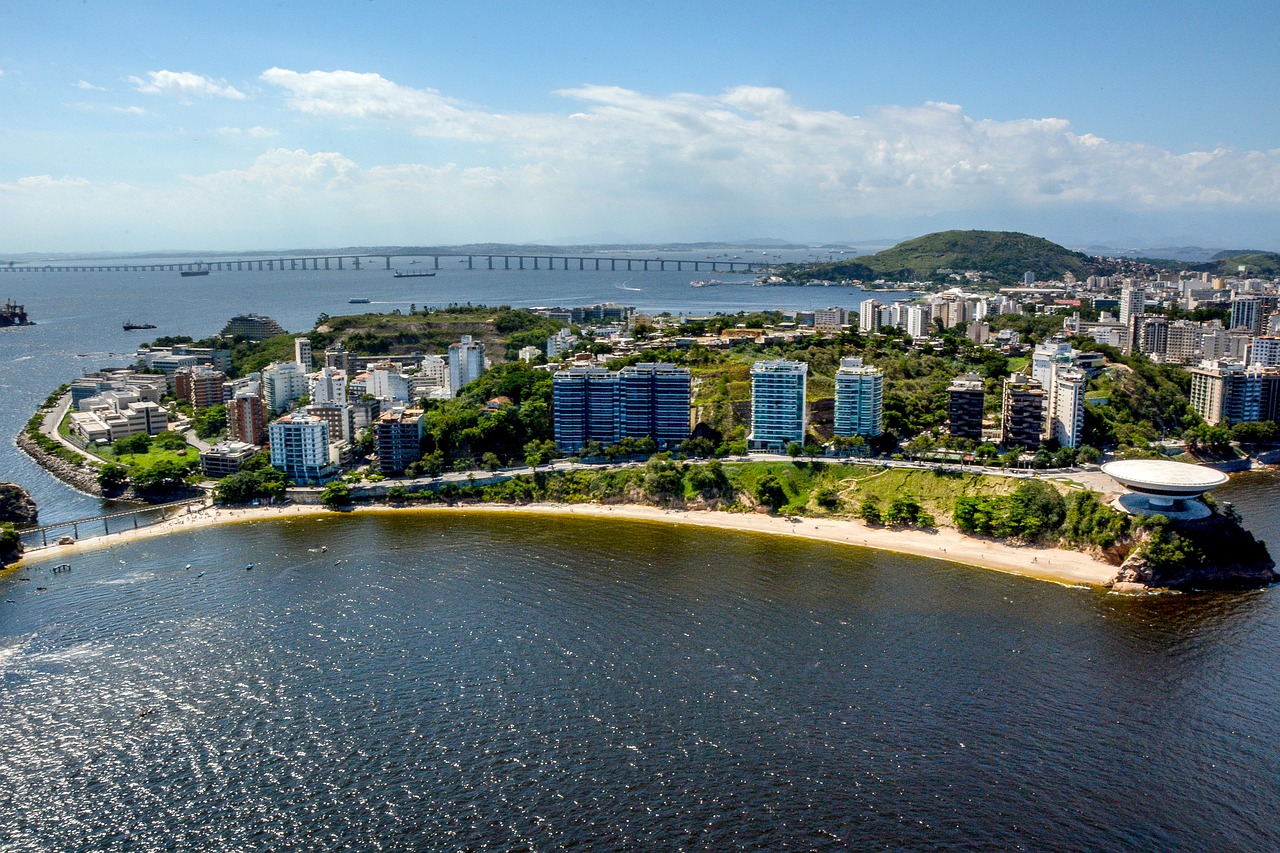 Morar em Niterói: vista aérea da mostrando a ponte Rio Niterói, a orla da praia e prédios da cidade